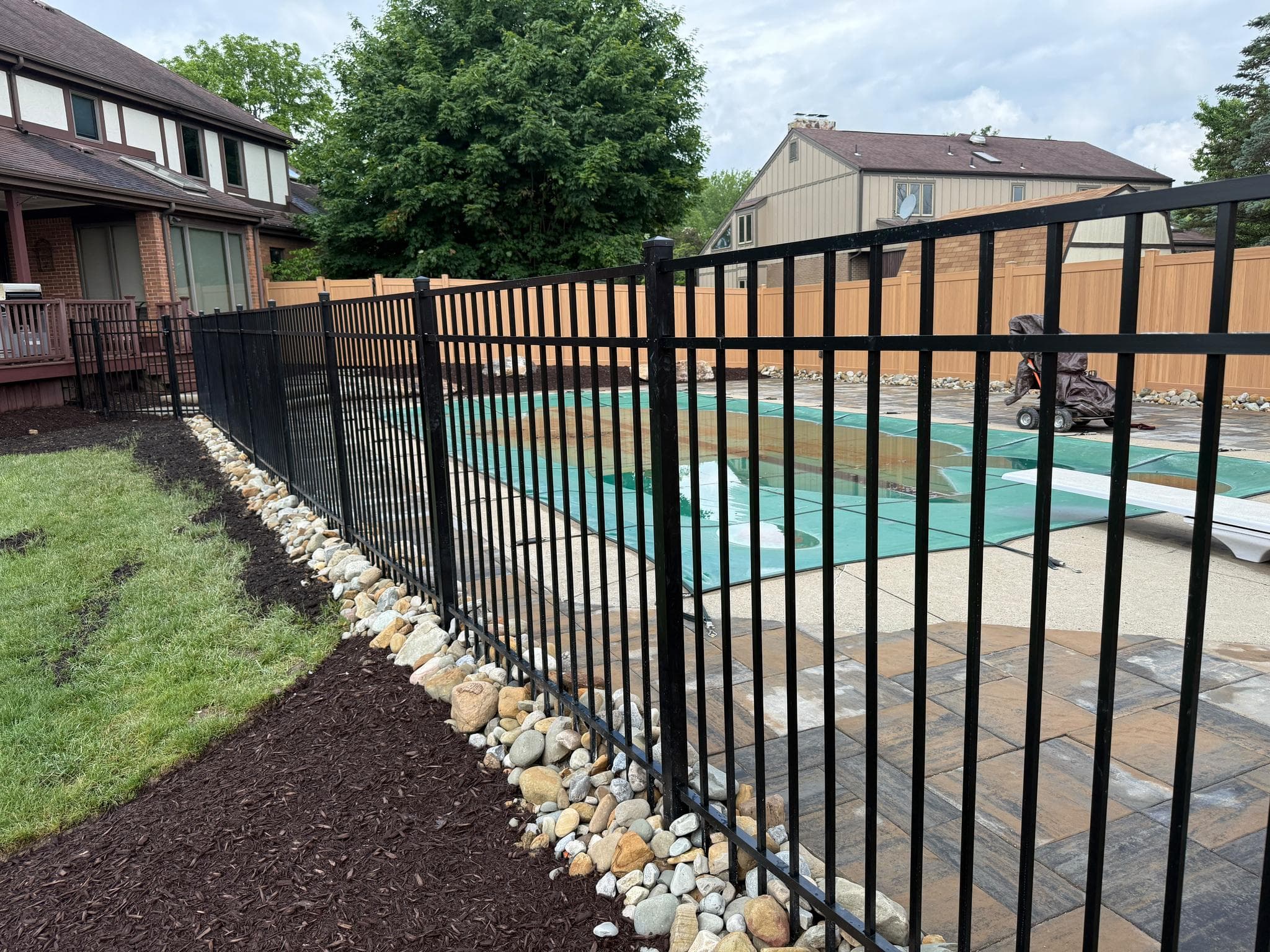Black aluminum fencing around a pool on a paver patio in Pittsburgh